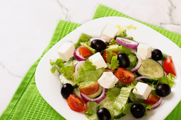 Fresh greek salad on white table