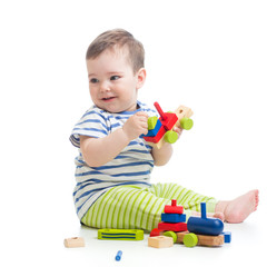 Baby boy playing with blocks toys looking away in surprise. Isolated on white.