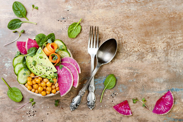 Vegan, detox Buddha bowl recipe with avocado, carrots, spinach, chickpeas and radishes. Top view, flat lay, copy space