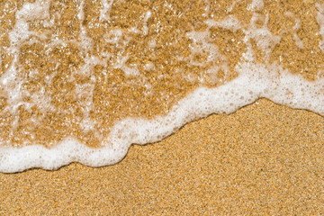 Beautiful crystal clear sea water, Gentle waves breaking on golden sand beach. From above with copy space