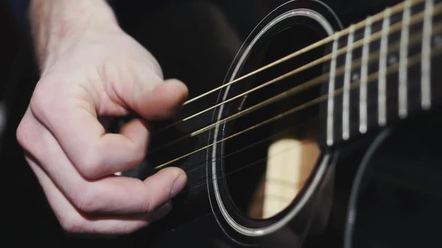 4k Man playing black classic guitar fingers