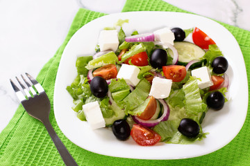 Fresh greek salad on white table