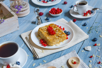 Pastry pie, tea, coffee and berries at blue rustic wood