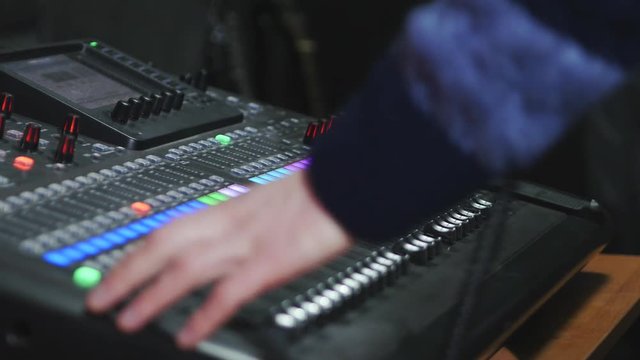 4k Sound designer takes the headphones with the mixing console in the studio