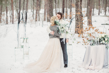 Beautiful stylish couple kissing in the winter park outside