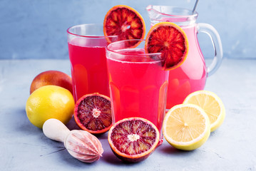 Glasses with blood orange and lemon lemonade Place for text Blue background