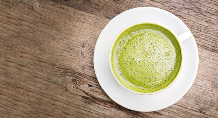 Top view of hot matcha green tea on wooden background