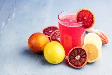 Glasses with blood orange and lemon lemonade Place for text Blue background