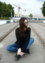Fototapeta premium Young girl in glasses walking in summer in the city. The concept of lifestyle and fashion