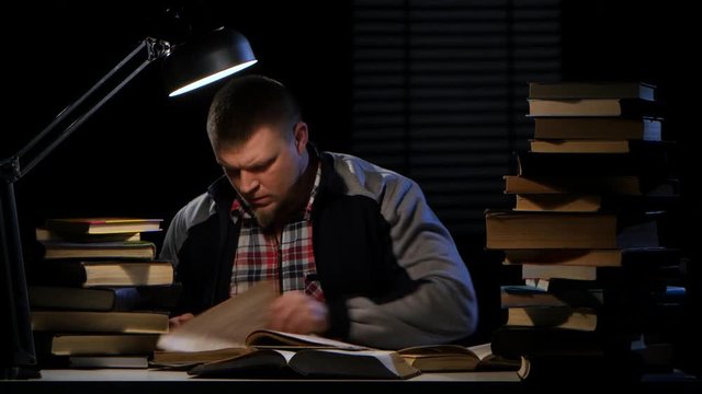 Guy looking for the right information in the book and could not find it. Black background
