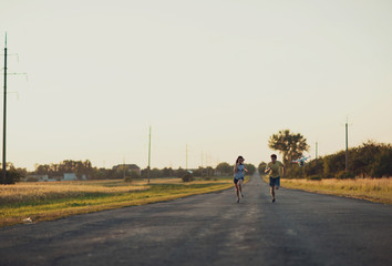 Fototapeta premium young woman and her man running on the broad road