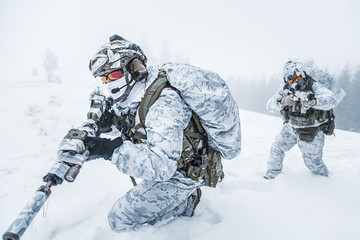 Winter arctic mountains warfare. Action in cold conditions. Pair of special forces weapons in...
