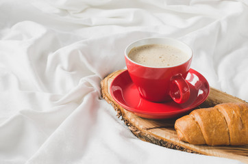 Cappuccino, Chocolate and Croissant on a Bed.