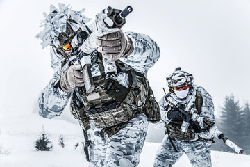 Winter arctic mountains warfare. Action in cold conditions. Pair of special forces weapons in forest somewhere above the Arctic Circle, low angle view
