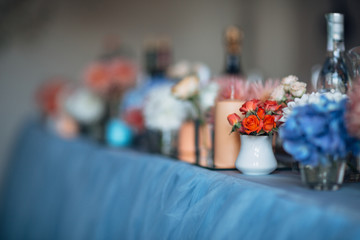 The candles and vases with flowers  stand on the wedding table