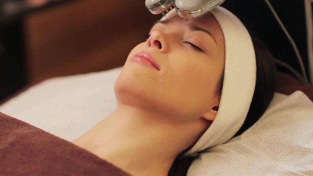 young woman having face microdermabrasion at spa
