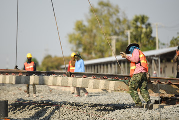 Construction team work in standard construction safety uniform installing precast concrete railway in mega project construction site