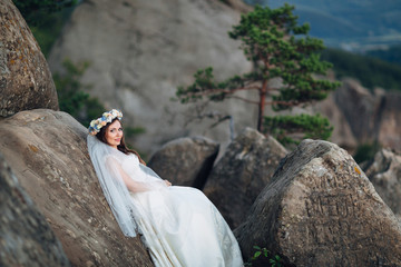 The charming bride stands near  stones
