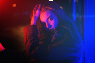 Sexy young beauty woman posing over night city dramatic red and blue neon background