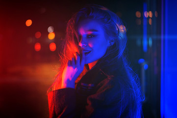 Obraz na płótnie Canvas Sexy young beauty woman posing over night city dramatic red and blue neon background