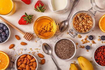 Ingredients for a healthy breakfast - granola, honey, nuts, berr