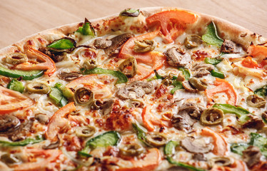 Rustic pizza with salami, mozzarella, olives and basil top view with copy space