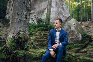 The handsome groom sitting on the ground