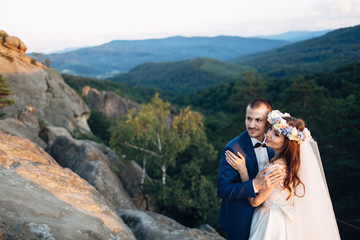 Naklejka premium The lovely couple in love embracing in the forest