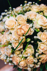 Bouquet tea rose with wedding rings close up.