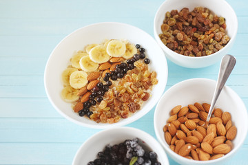 Healthy breakfast. Oatmeal with banana, almond nuts, blueberries and raisins.