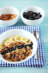 Healthy breakfast. Oatmeal with banana, almond nuts, blueberries and raisins.