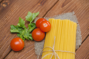 На столе лежат спагетти с помидорами.