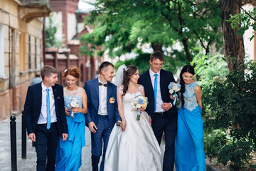 The brides,bridesmaids and groomsmen walking along street