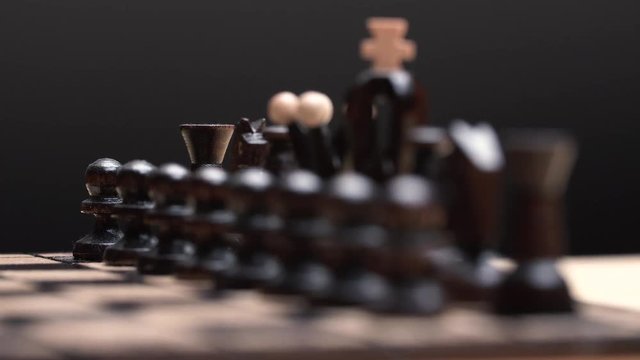 chess closeup, wooden chess board, business concept, black background. slide camera. Studio.