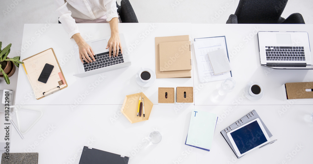 Wall mural Hands of unrecognisable businesswoman working on her business laptop at office desk.