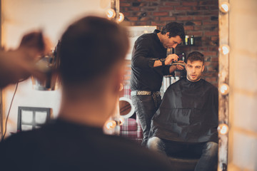 Handsome man at the hairdresser getting a new haircut