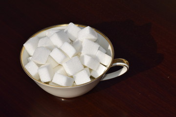 Würfelzucker in einer Goldrandtasse