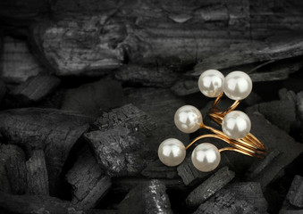 Jewellery golden ring with pearls on black background