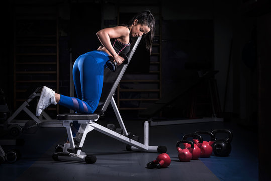 Beautiful Woman Bodybuilder Lifting Dumbbells on Adjustable Bench 