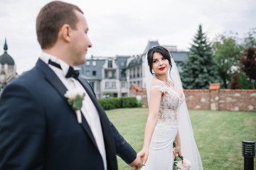 beautiful and young bride and groom standing outdoors