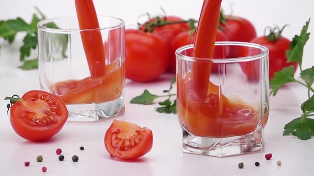 Pouring Tomato Juice Into Glass. Light Background. Slow Motion.
