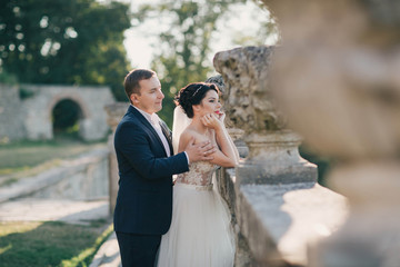 beautiful and young bride and groom standing outdoors