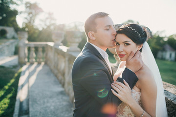 beautiful and young bride and groom standing outdoors