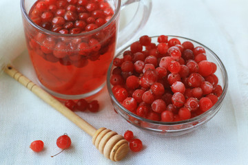  cranberry juice and berries in a glass on a white linen tablecloth, close up, concept of health