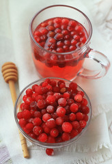  cranberry juice and berries in a glass on a white linen tablecloth, close up, concept of health