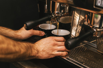 Barista prepares cappuccino in his coffeeshop close up
