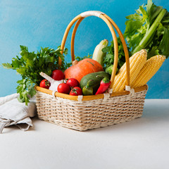 Basket of fresh vegetables on a blue background.