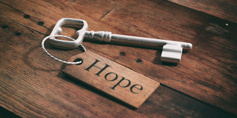 Old key with tag hope on a wooden background. 3d illustration