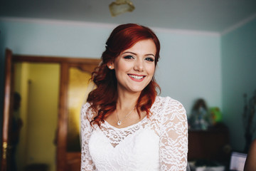 The smilling bride stands in the room