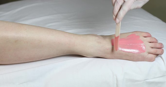 Process depilation female legs and hands in a beauty salon 